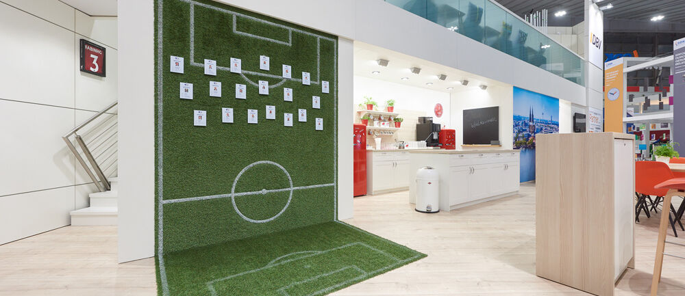 [Translate to English:] Messestand AXA, Messe DKM, Versicherungsbranche, Isingermerz, Messebau, Messedesign, zweigeschossig, Doppelstock, Markeninszenierung