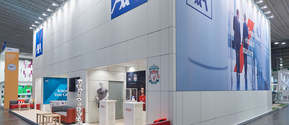 [Translate to English:] Messestand AXA, Messe DKM, Versicherungsbranche, Isingermerz, Messebau, Messedesign, zweigeschossig, Doppelstock, Markenraum